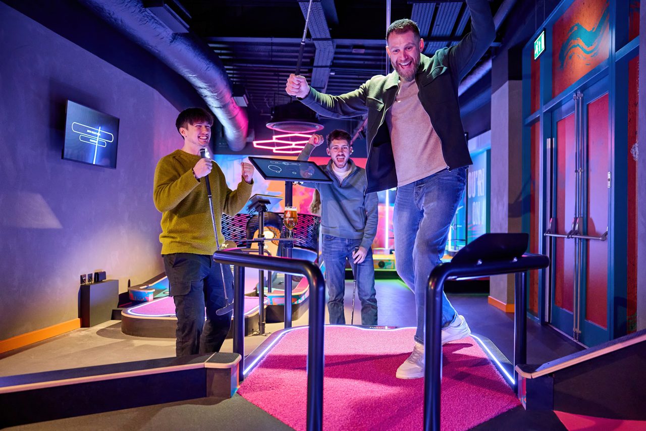 Two adults playing shuffleboard.