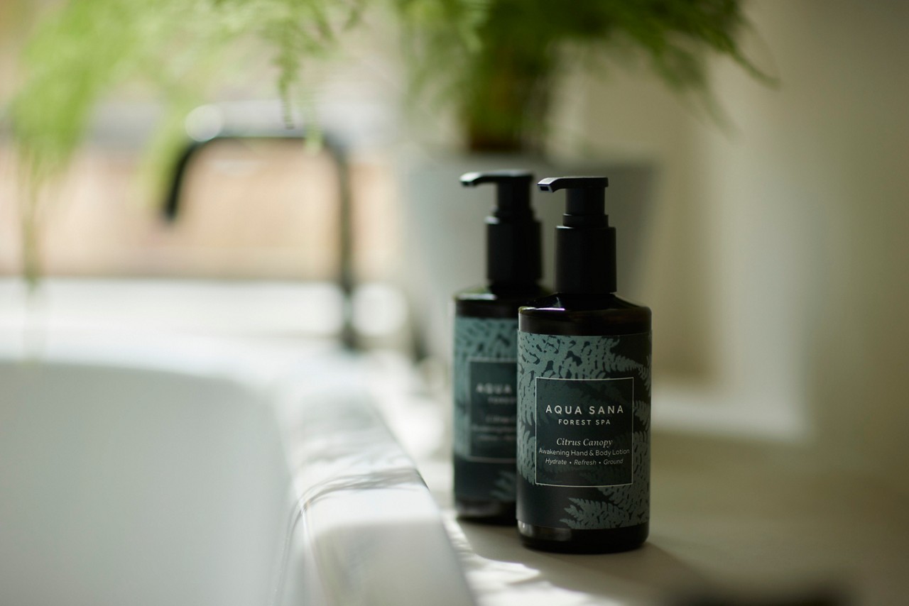 hand & body lotion and hand & body wash by the side of the bath
