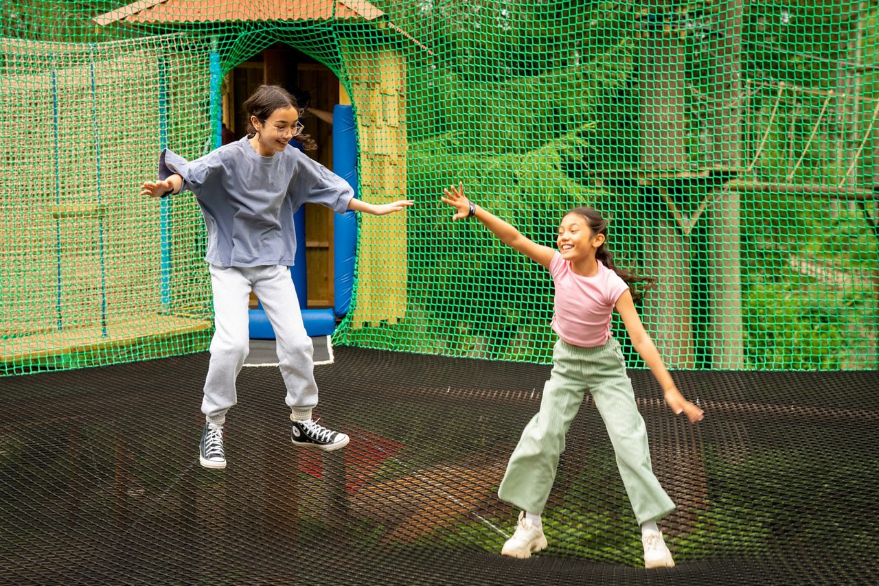 Two children jumping on the Adventure Nets activity.