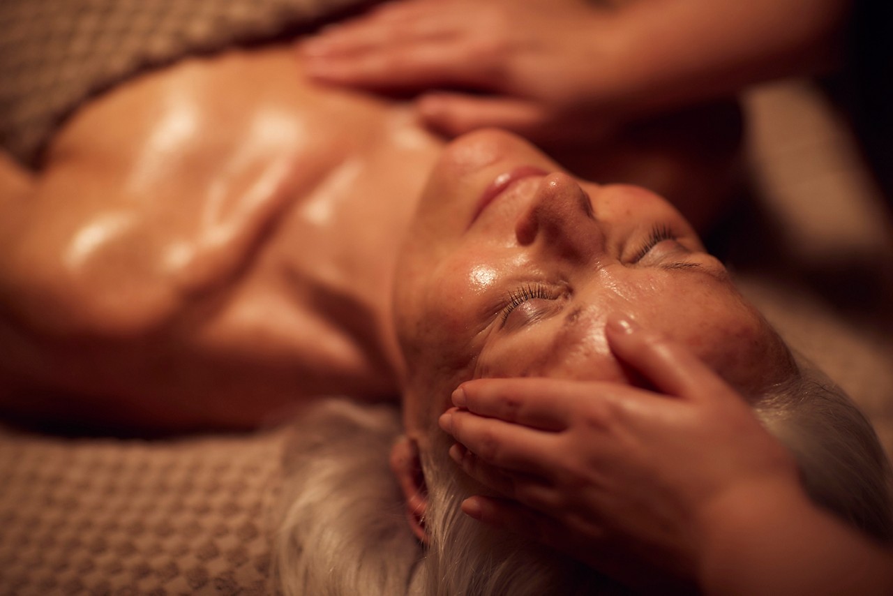 Spa therapist giving a woman a facial treatment.