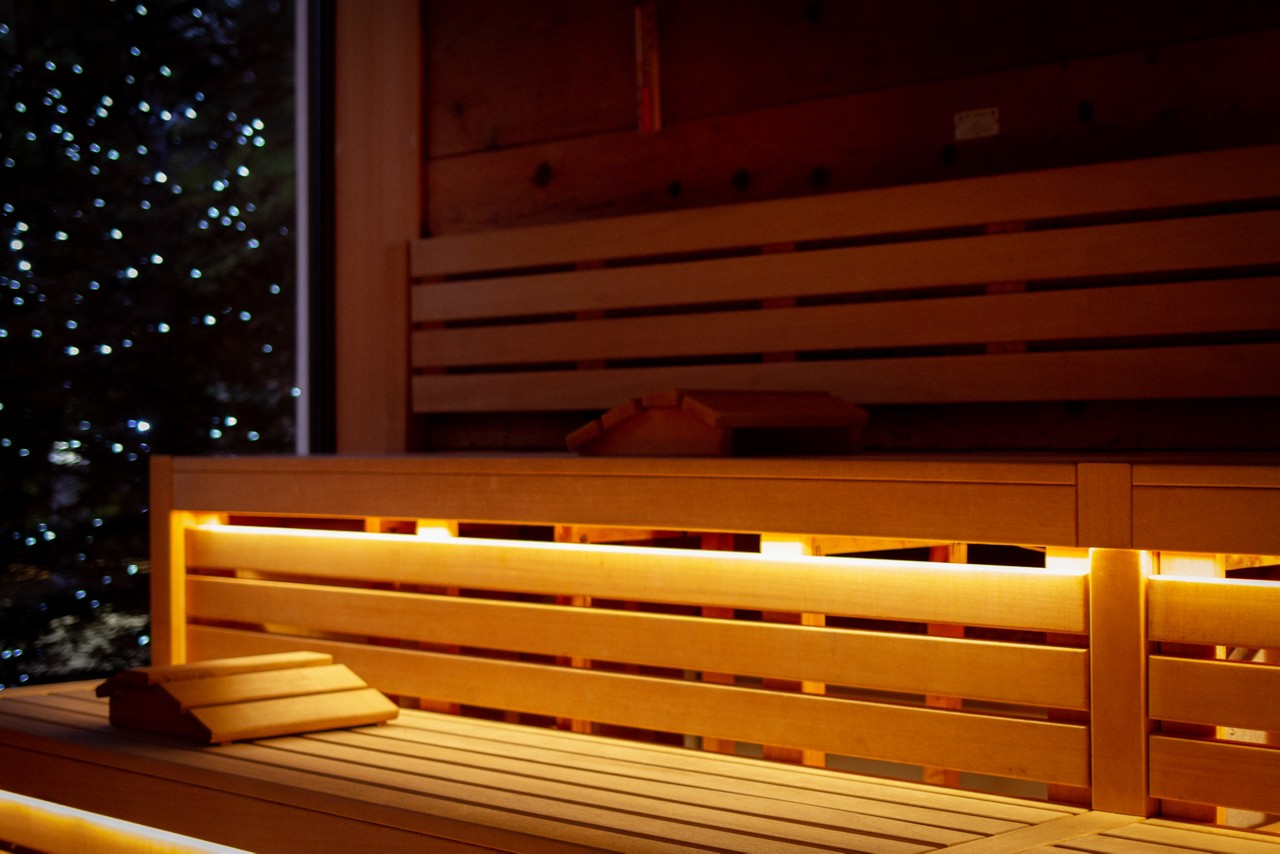 Inside the Nordic Sauna with views out to the twinkling lights of the forest.