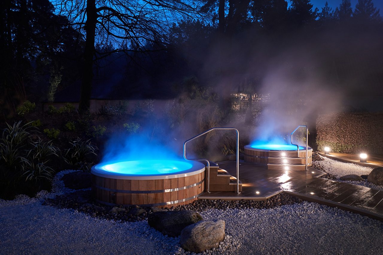 Steaming hot tubs in the Hot Springs Garden at night.