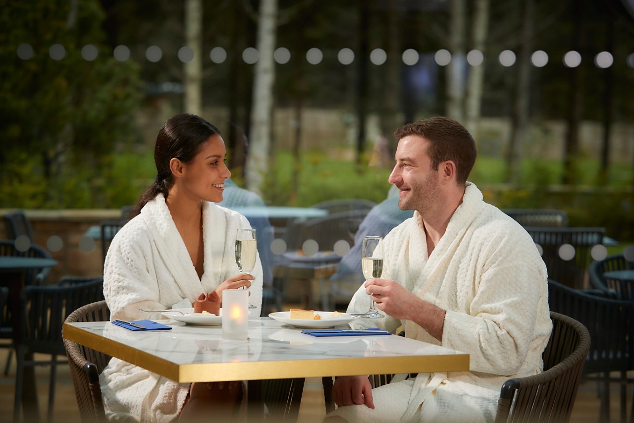 Couple sat in the Vitalé Café Bar enjoying a sweet treat and a glass of Prosecco.
