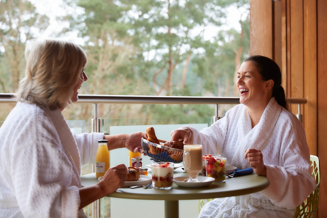 Mother and daughter enjoying breakfast on their Spa Suite balcony.
