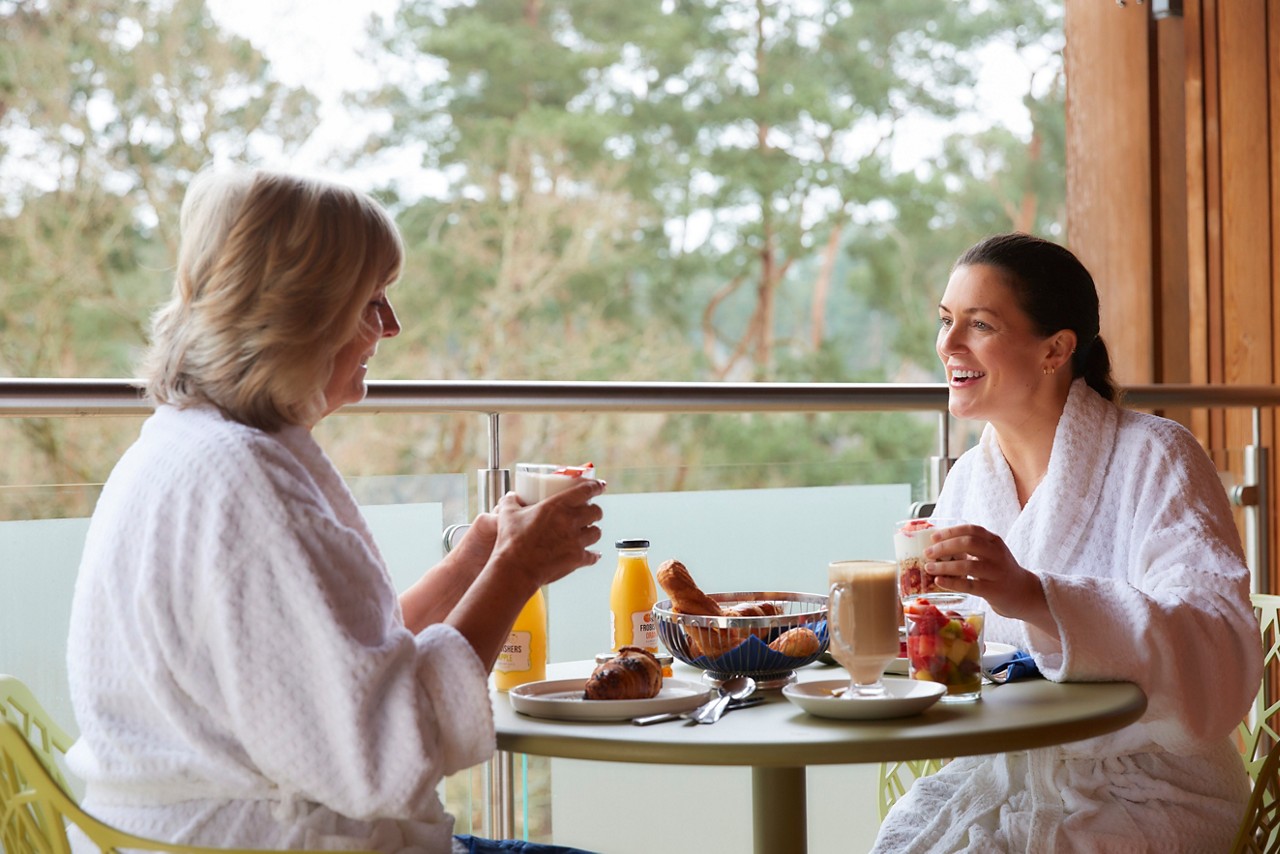 Mother and daughter enjoying breakfast on their Spa Suite balcony.