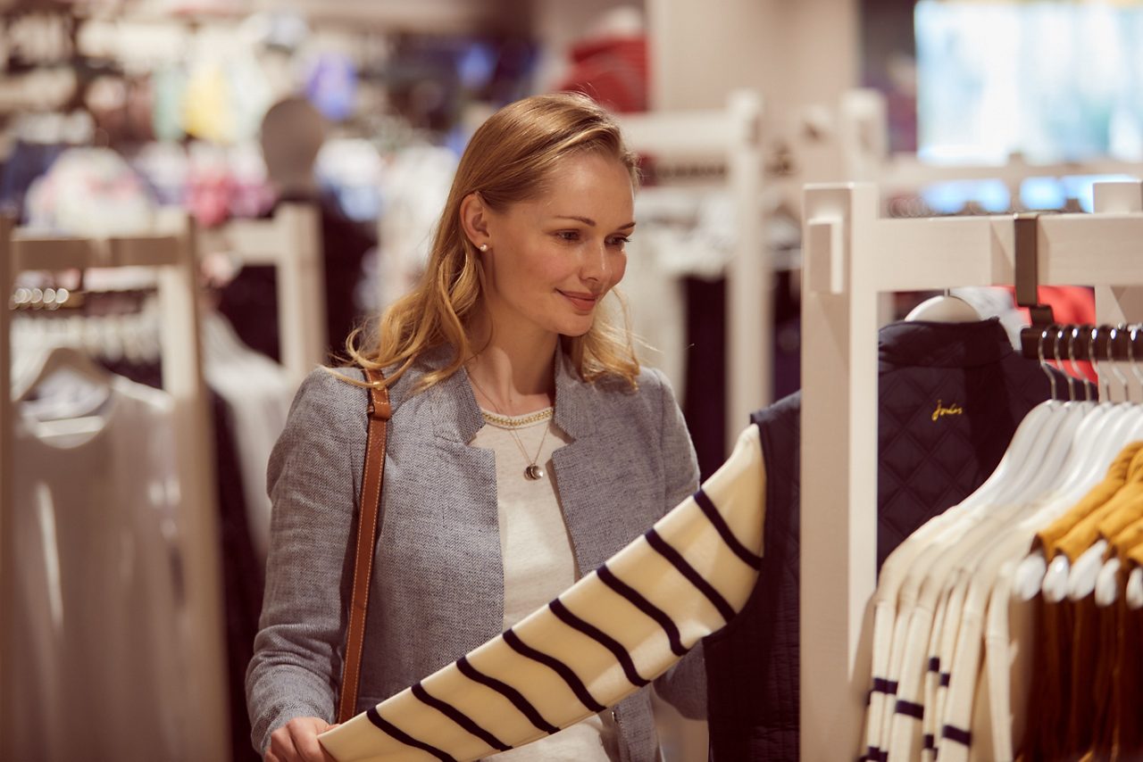 A lady browsing lothes rails. 