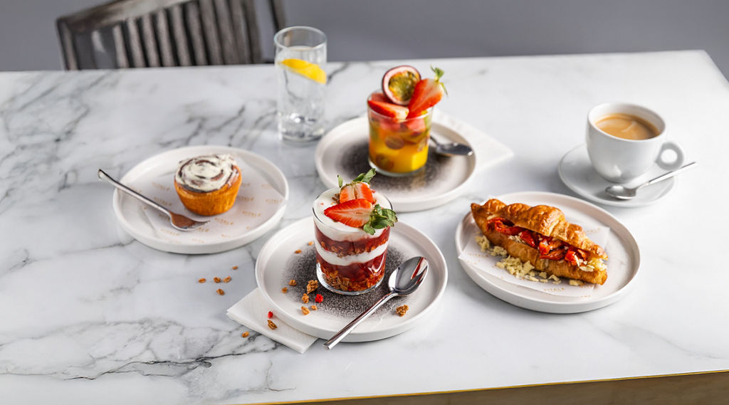 A selection of breakfast items including granola and fruit salad.