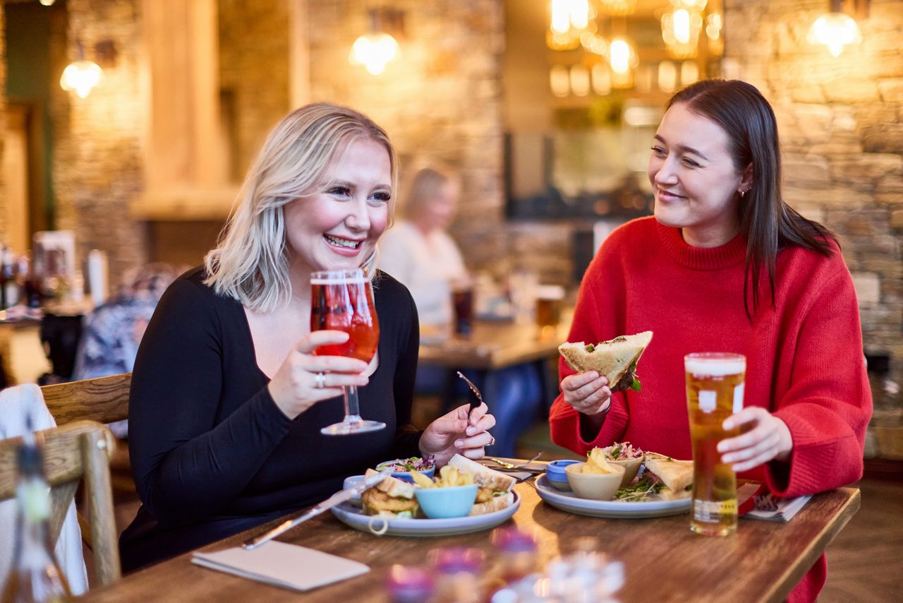 Two people enjoy food inside The Dozing Duck.