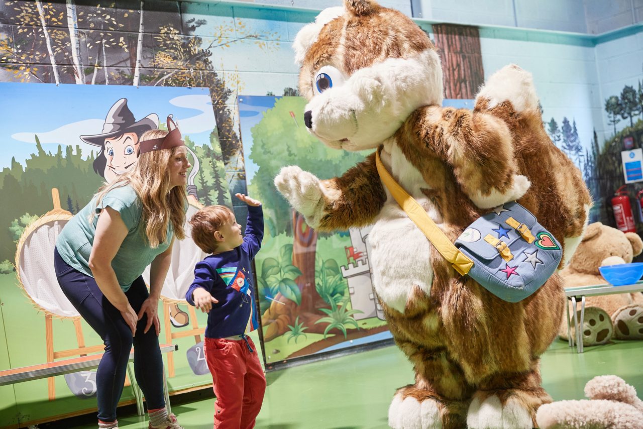 Young boy high fiving Chestnut the squirrel. 
