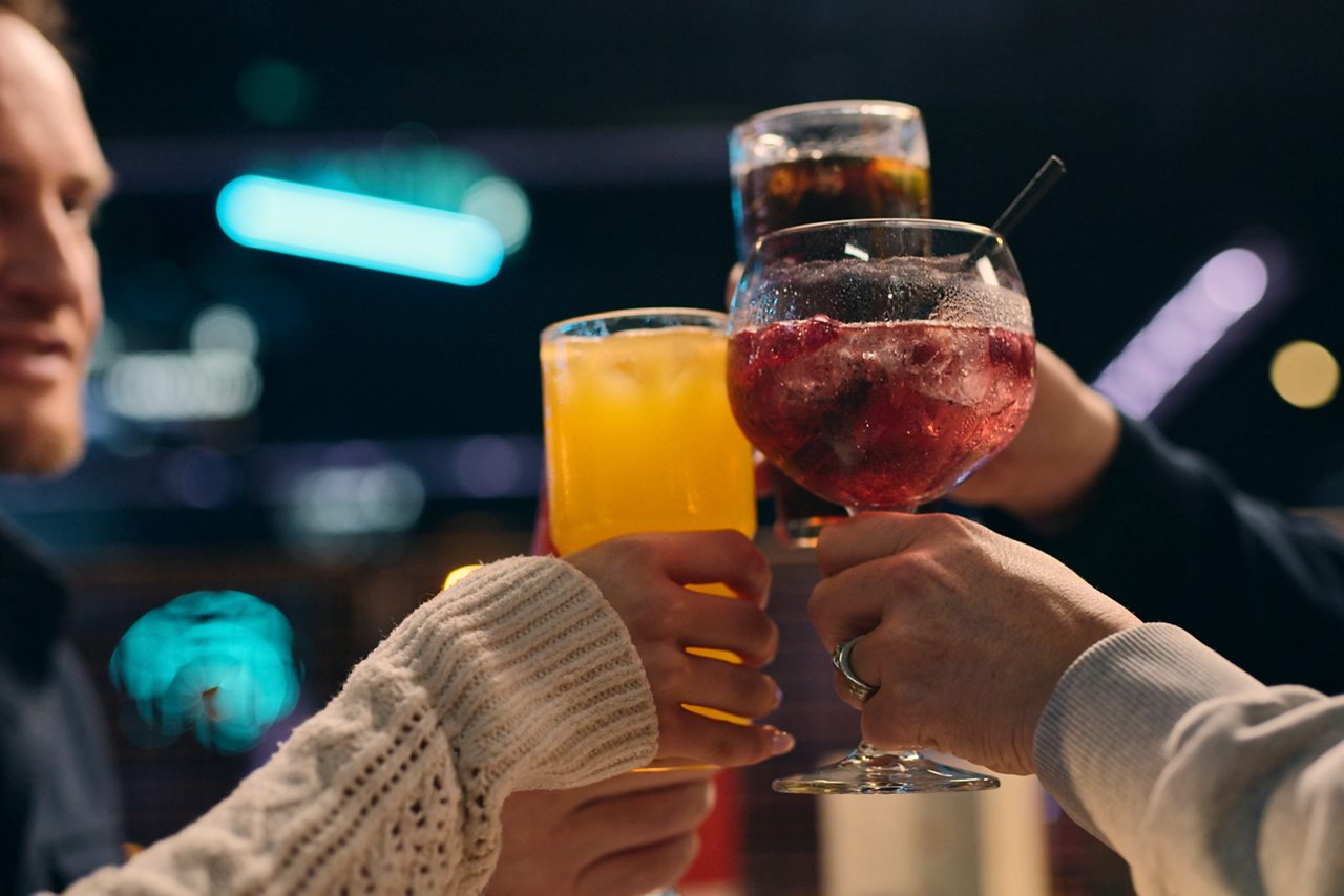 People holding up their drinks together.