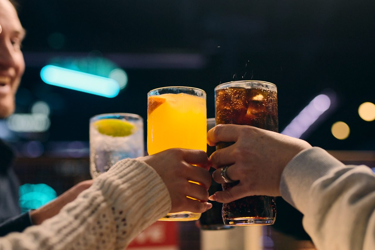 people doing cheers with drink glasses 
