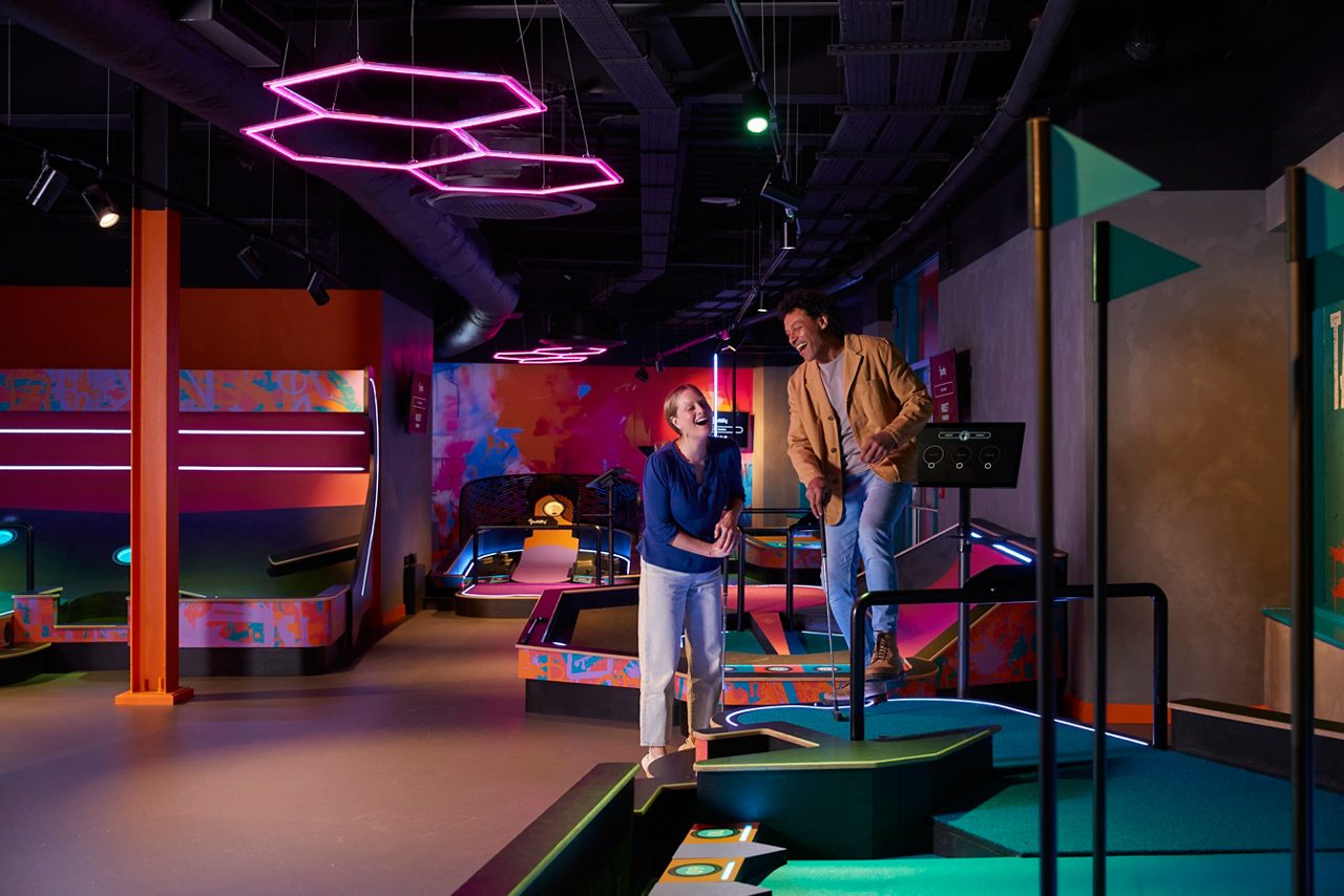 Two adults playing Puttify in the Entertainment Hive.