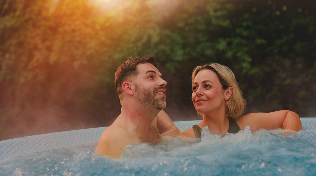 Two people smiling in a hot tub