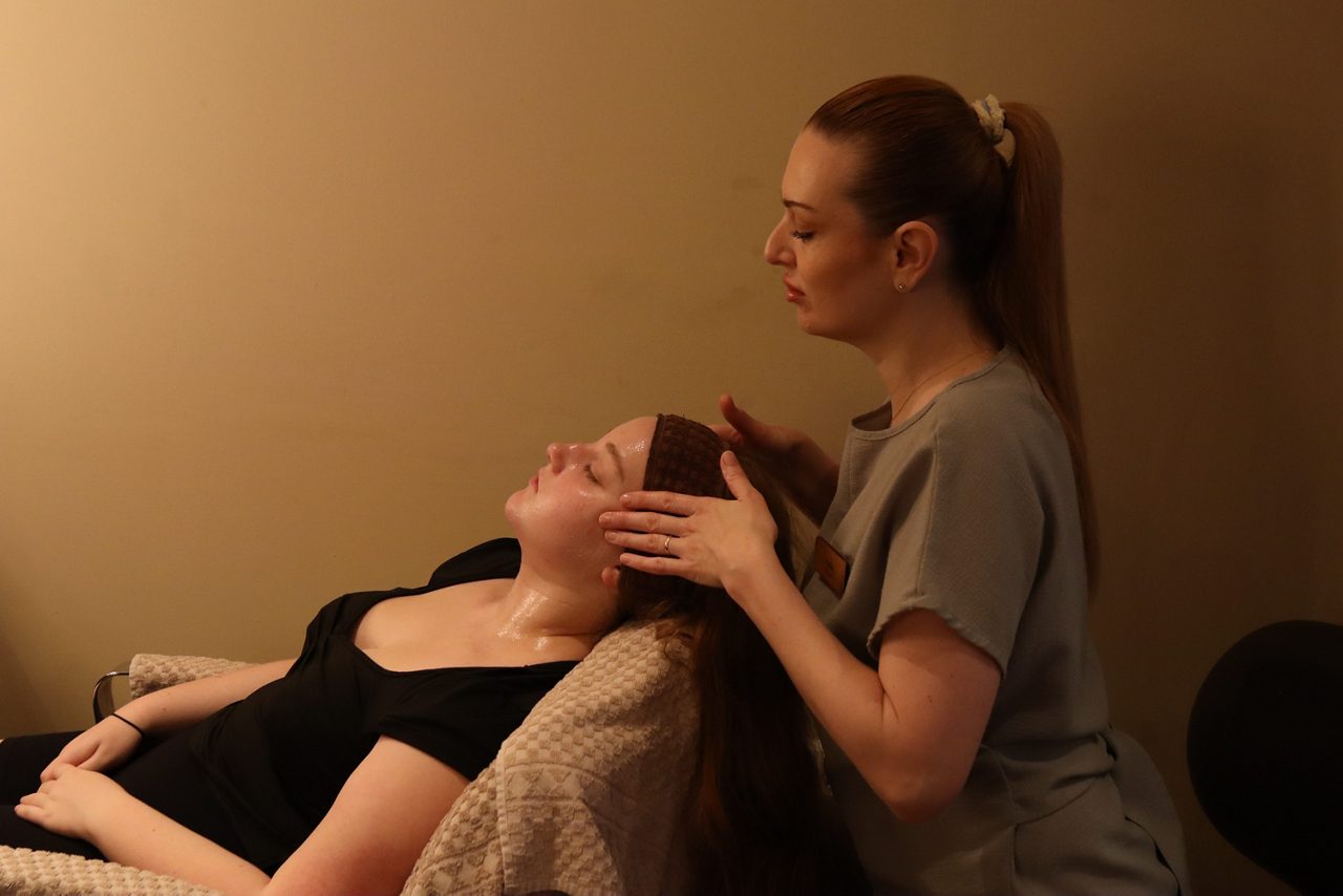 Spa therapist doing a facial.