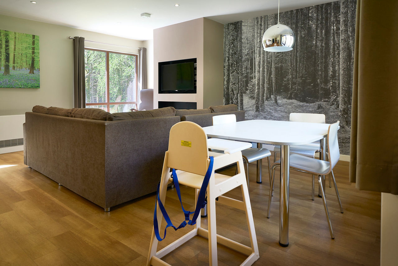A mother feeding her child in a highchair in their lodge.