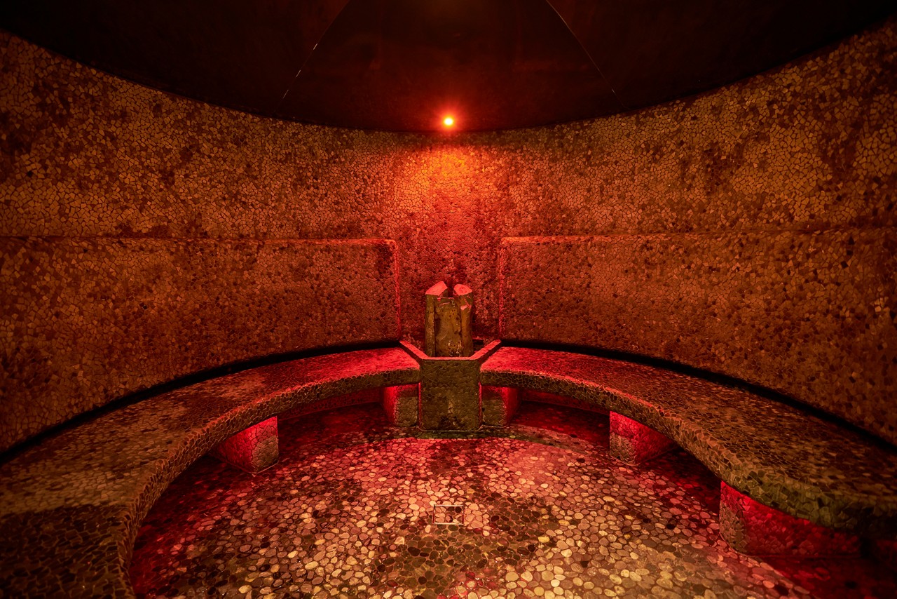 Volcanic Steam room with curved bench seating.
