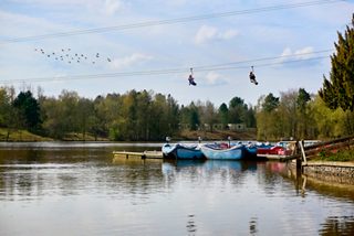 Two people on zip wiresd going over the lake.