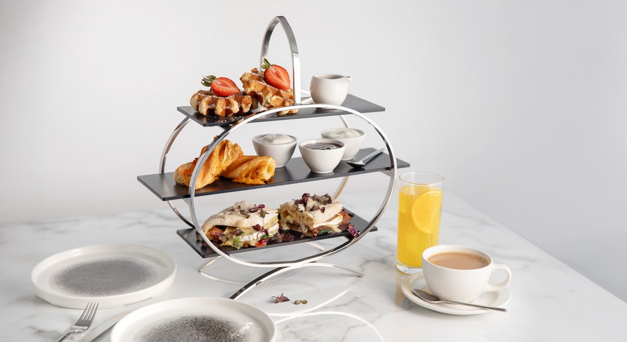 image of a three tier Vtale breakfast platter with a glass of orange juice and a cup of tea