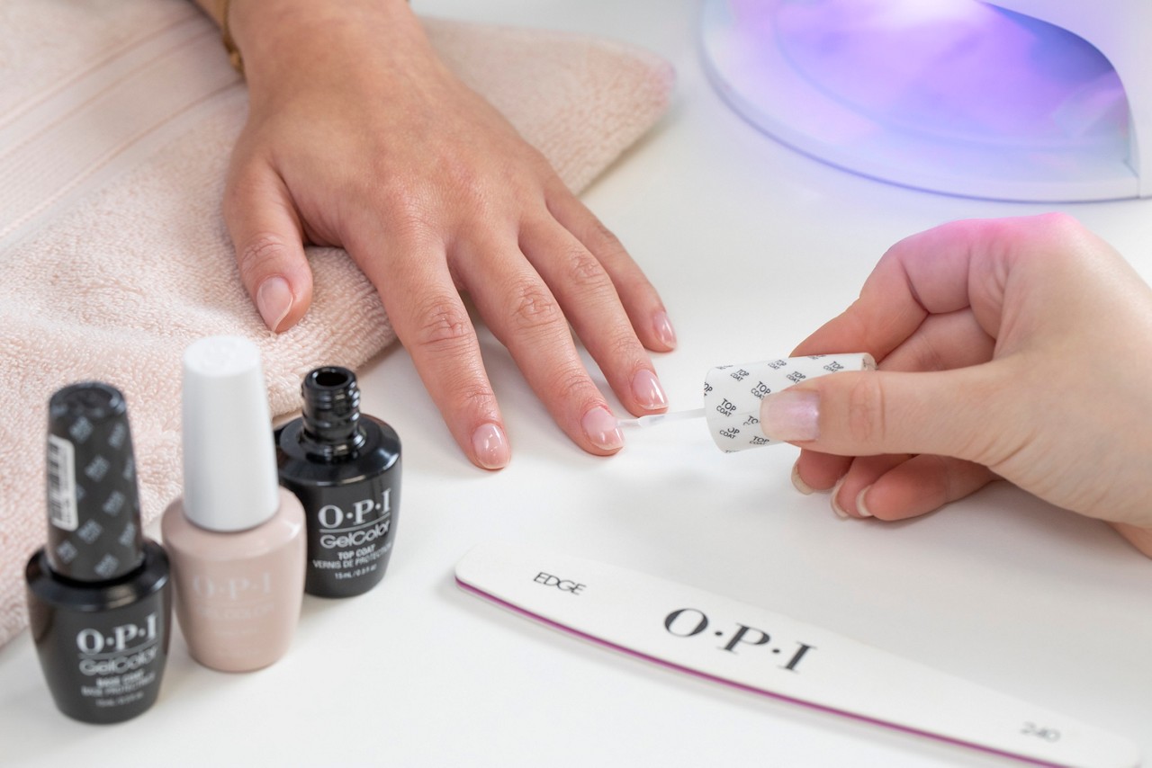 OPI GelColor being applied to a woman's fingernails.
