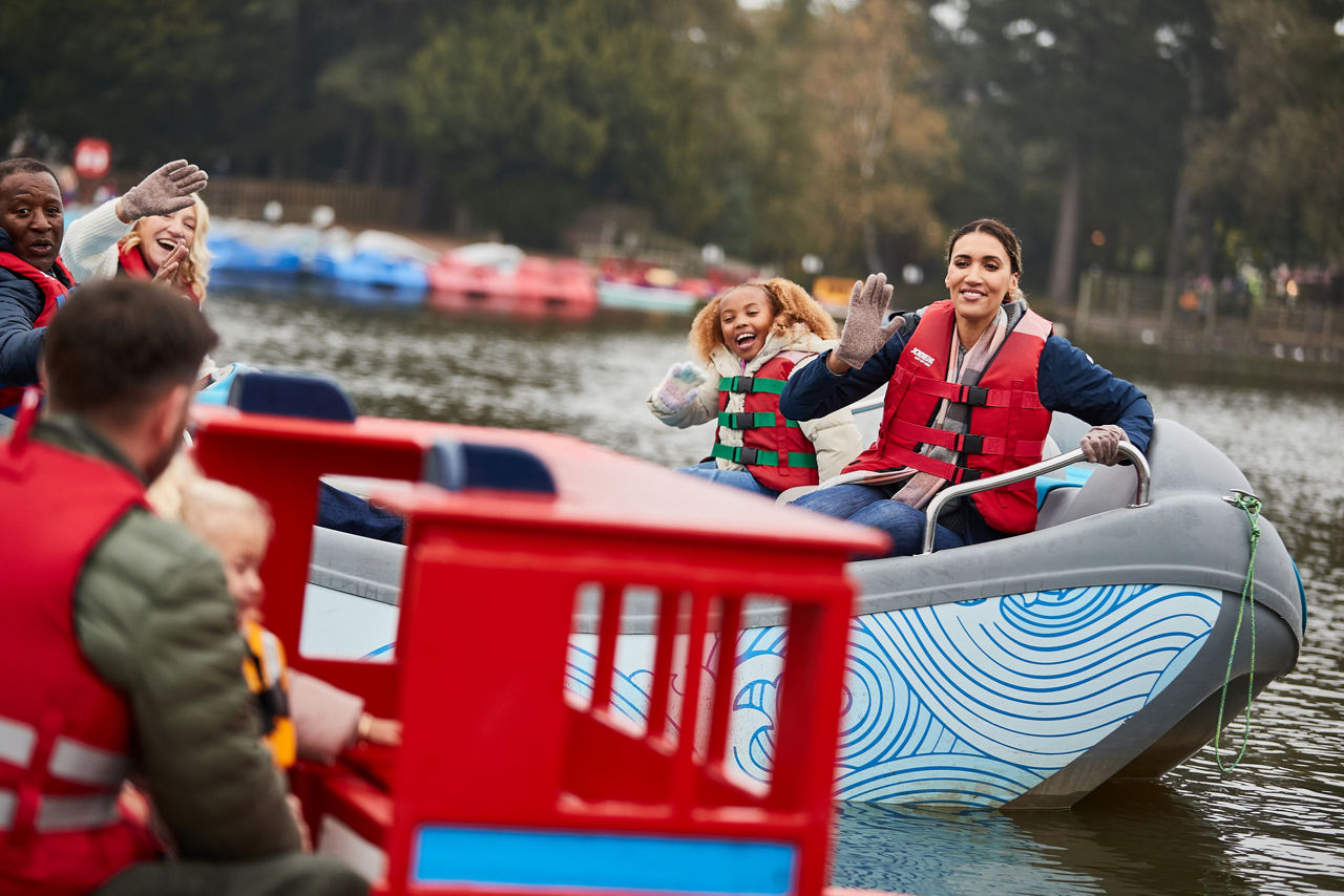 A family waving at each other on the boat hire activity.