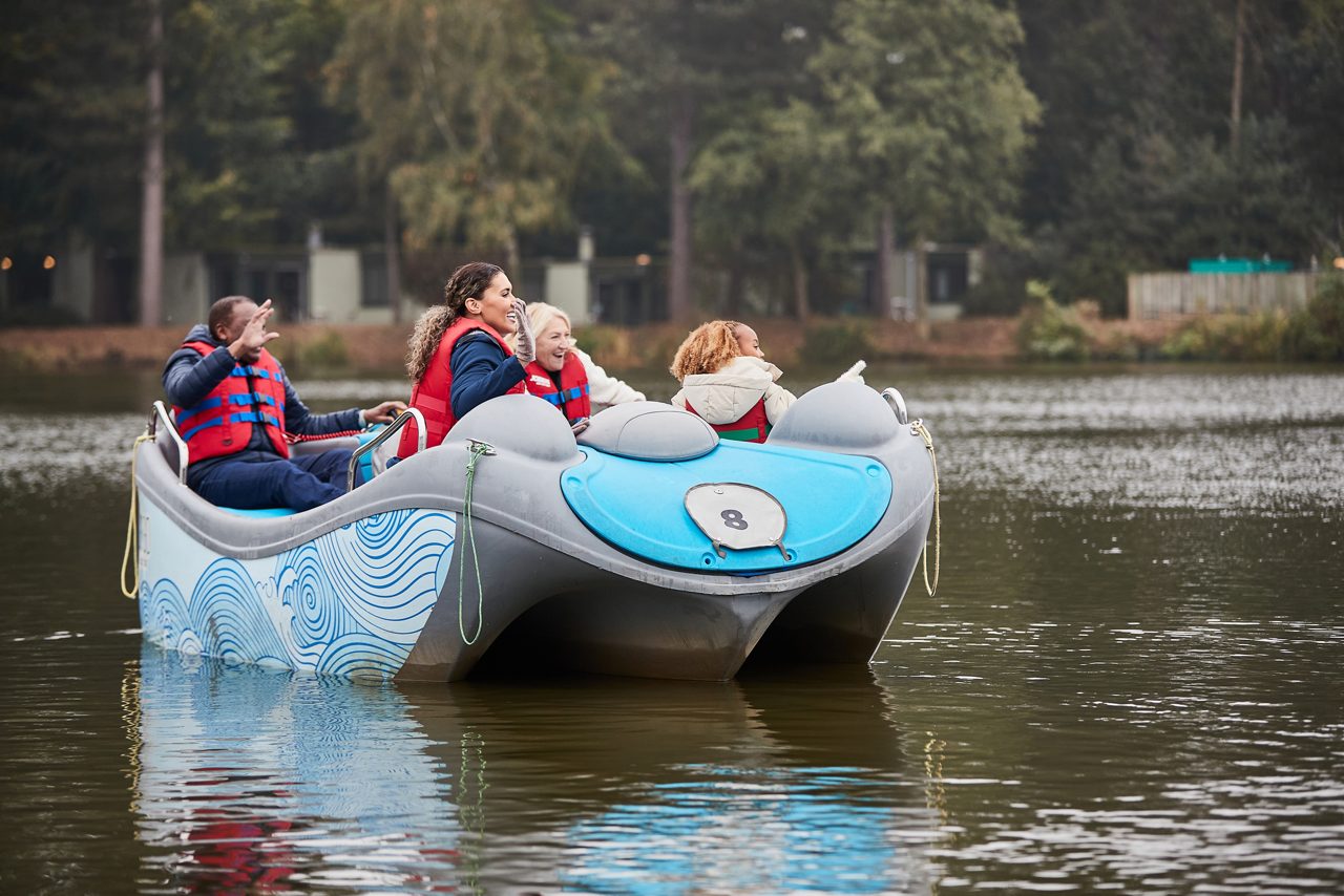 Family sitting in an electric boat on the lake.