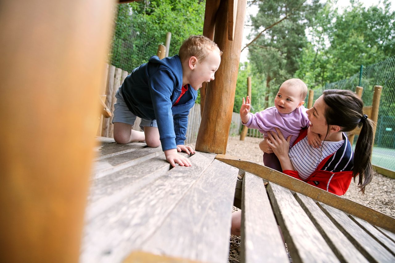 Baby and toddler playing on the outdoor play area.
