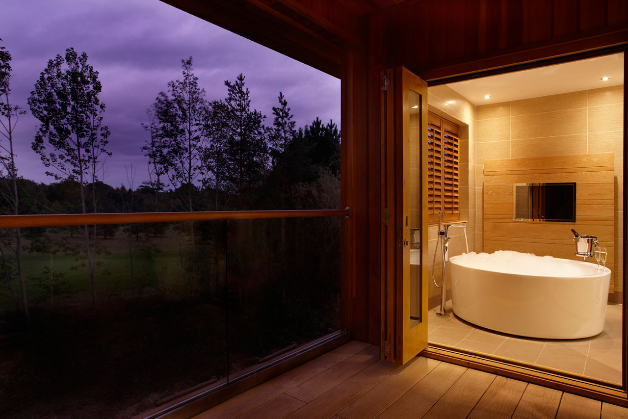 Spa Suite balcony in the evening leading to a large bubble bath.