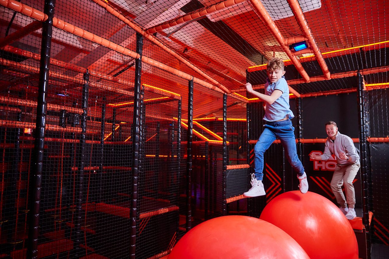 Two children jumping on the Adventure Nets activity.