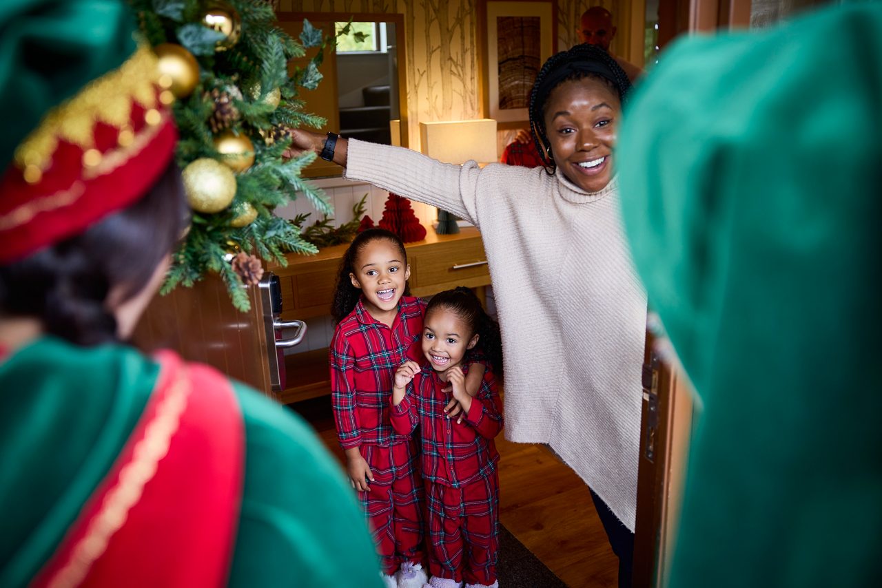 Elves being greeted at a lodge door. 