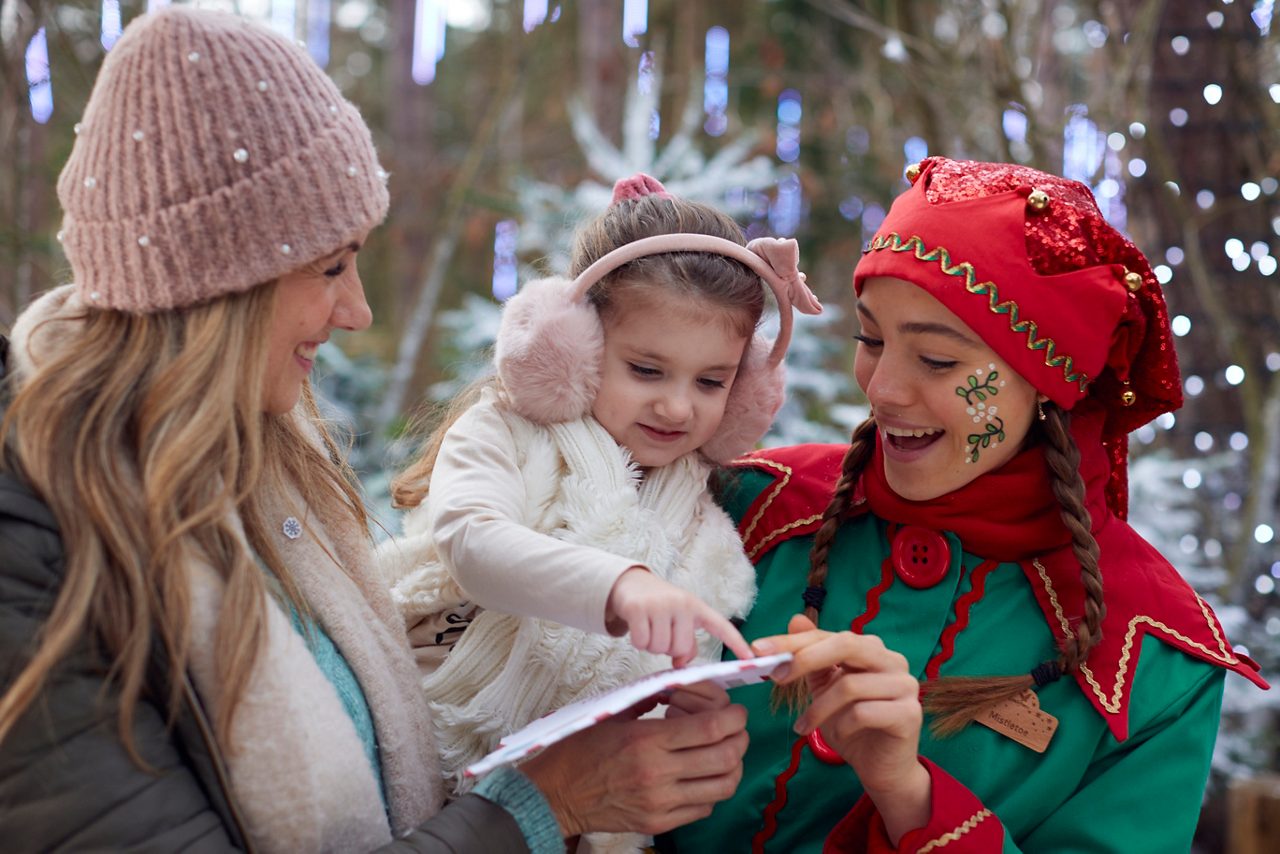 Young girl looking at a letter with an elf.