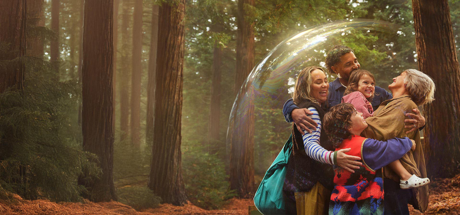 A family holding each other in a hug whilst surrounded by a bubble.