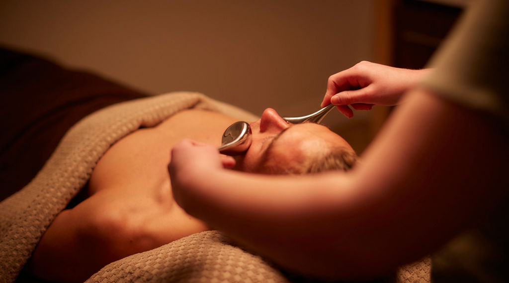 Man having a facial with smooth metal probes.