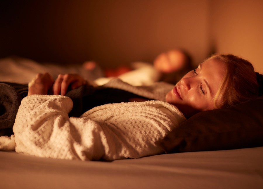 Woman laying in a fluffy spa robe.
