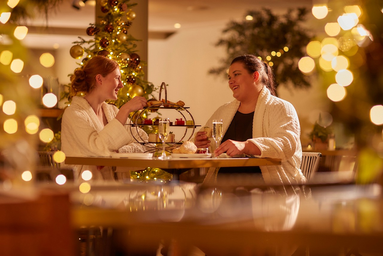 Two women eating a Festive Afternnon Tea in the Vitalé Café Bar.