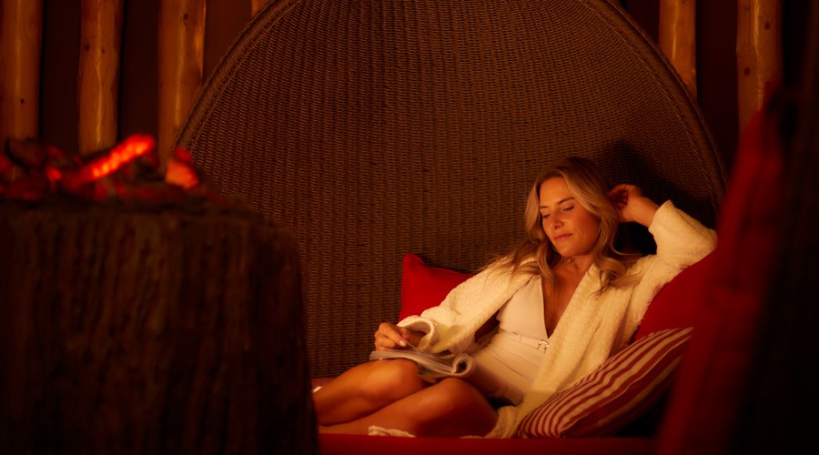 Woman relaxing as she reads a book in the Fireside Relax.