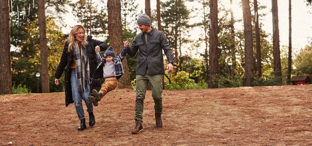 A family walking through the autumnal forest.