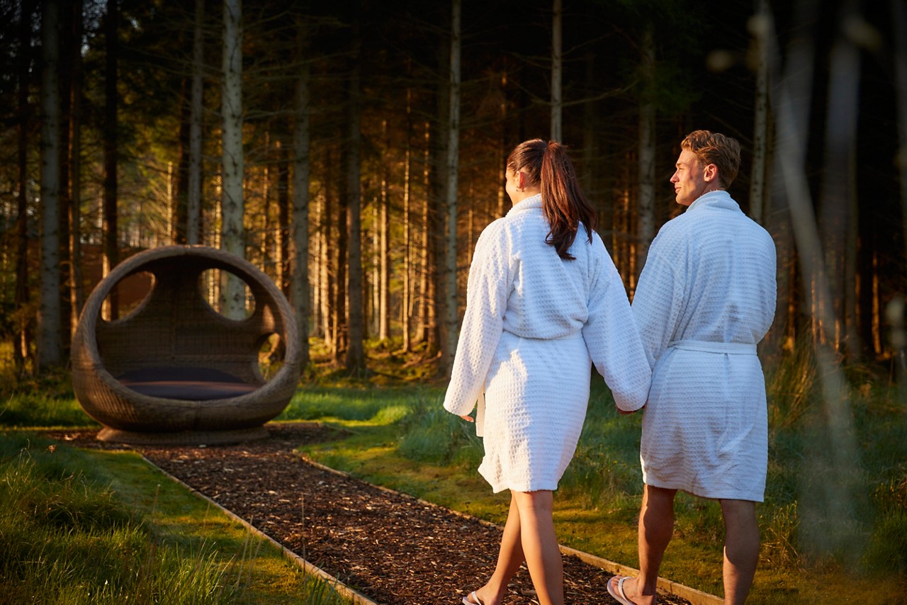 Woman snuggled in a large cocoon chair.