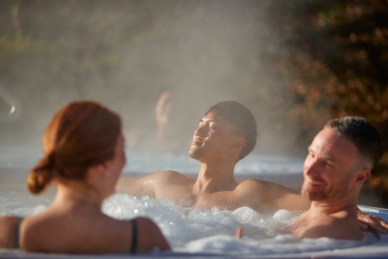 three people in an outdoor hot tub