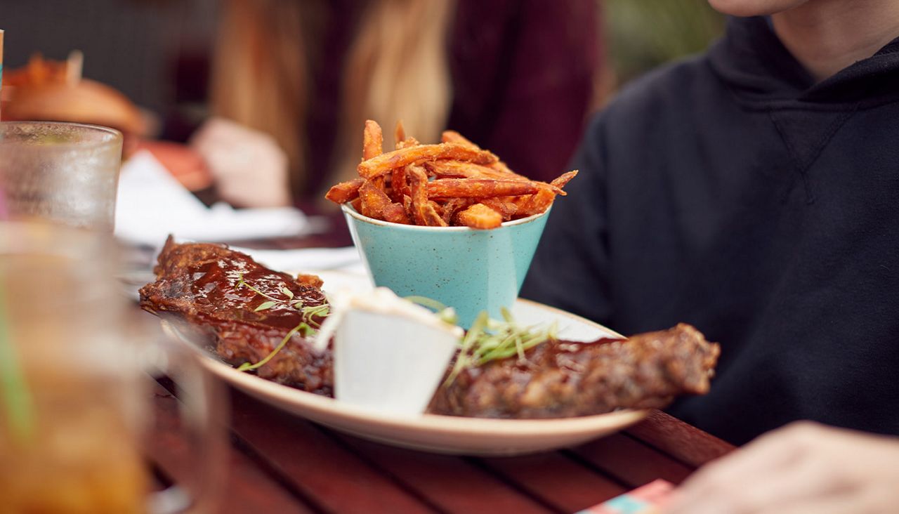 A close up of rack of ribs and a bowl of sweet potato fries
