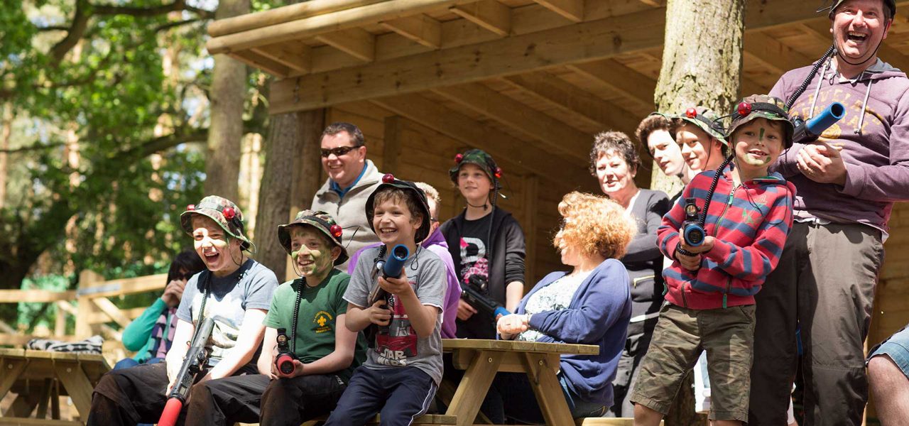 A group of various ages gathered to play laser combat in the forest