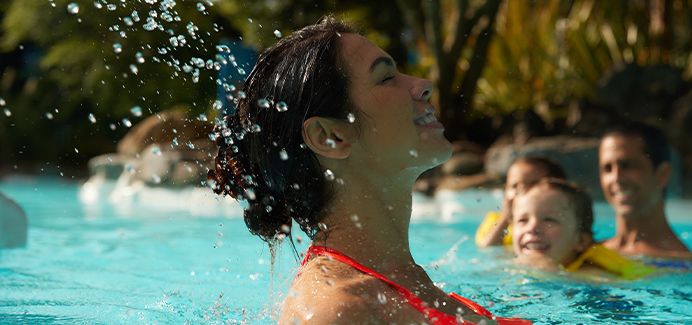 Woman brings head up out of pool, splashing water