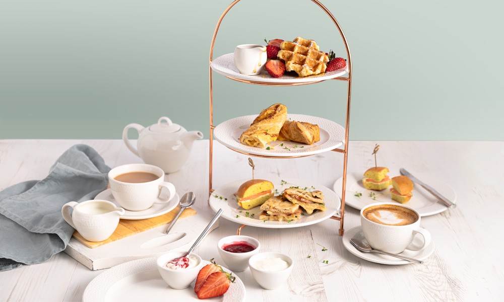 Stacked brunch served with a pot of tea.