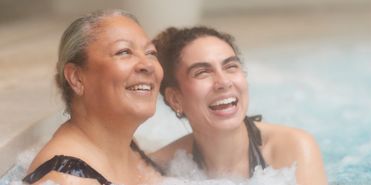 Two women soaking in a bubbling hot tub.