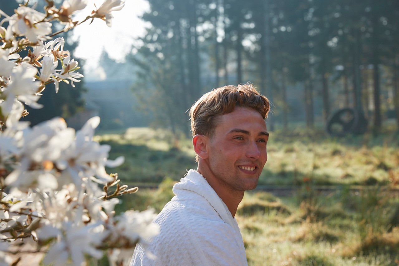 man outside by blossom tree