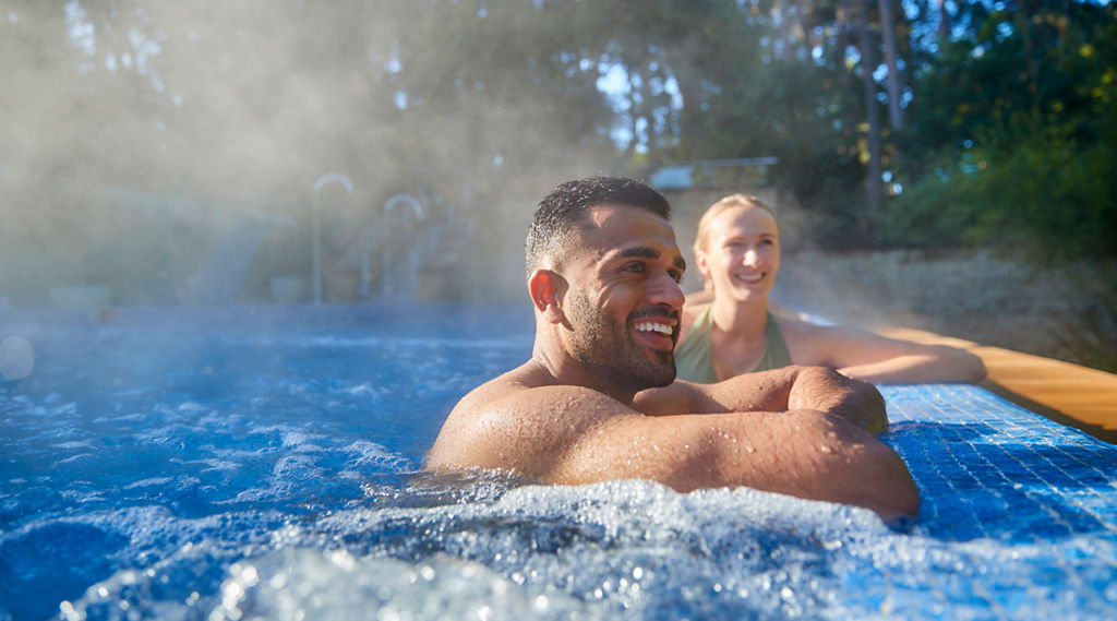 Two people smiling in a hot tub