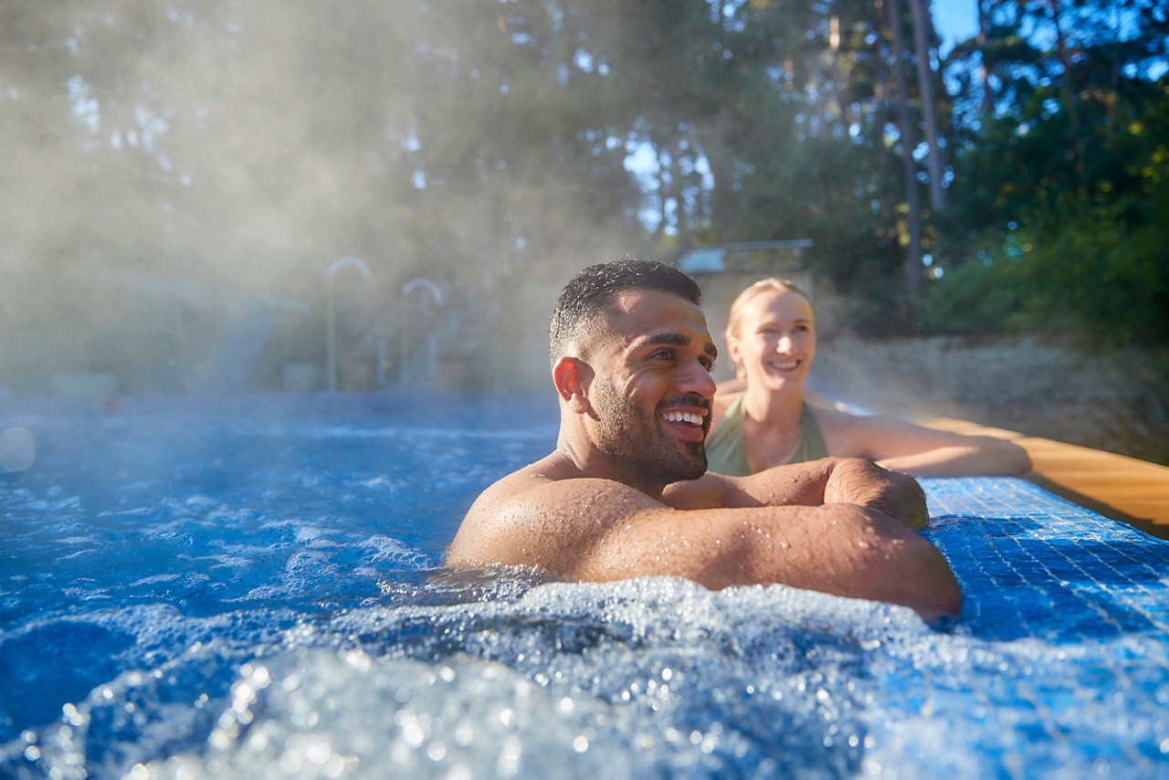 A man relaxing under a flowing water fountain.