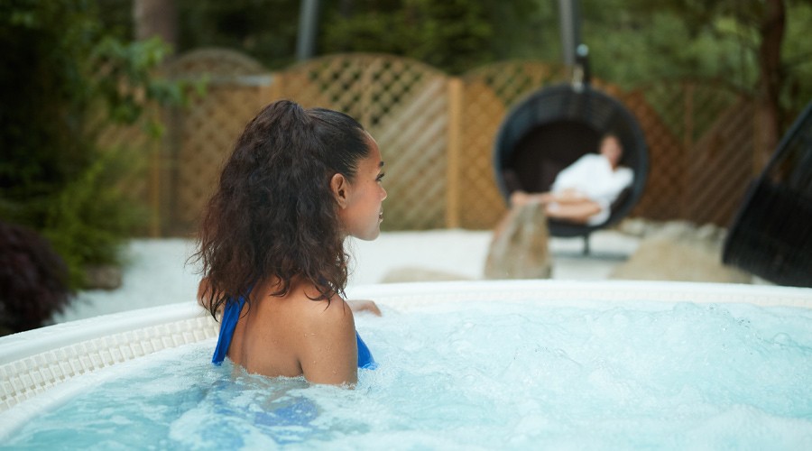 Woman soaking in a bubbling outdoor hot tub.