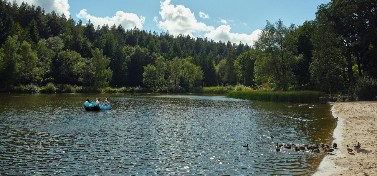 A family on an electric boat in the middle of the lake.