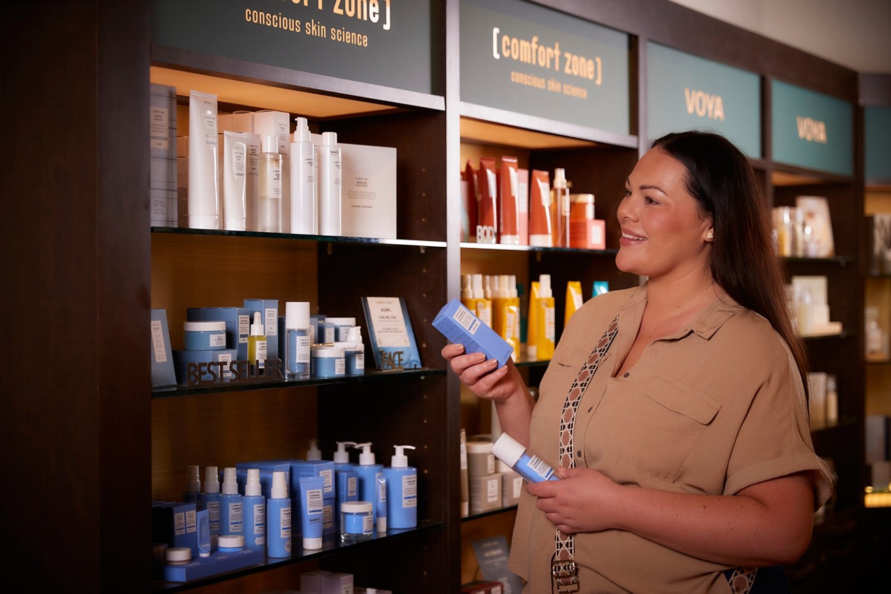a women in a spa shops looking at a gift set 