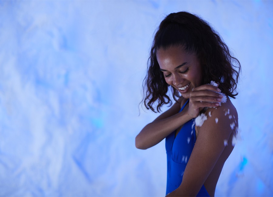 Woman applying ice to her skin.